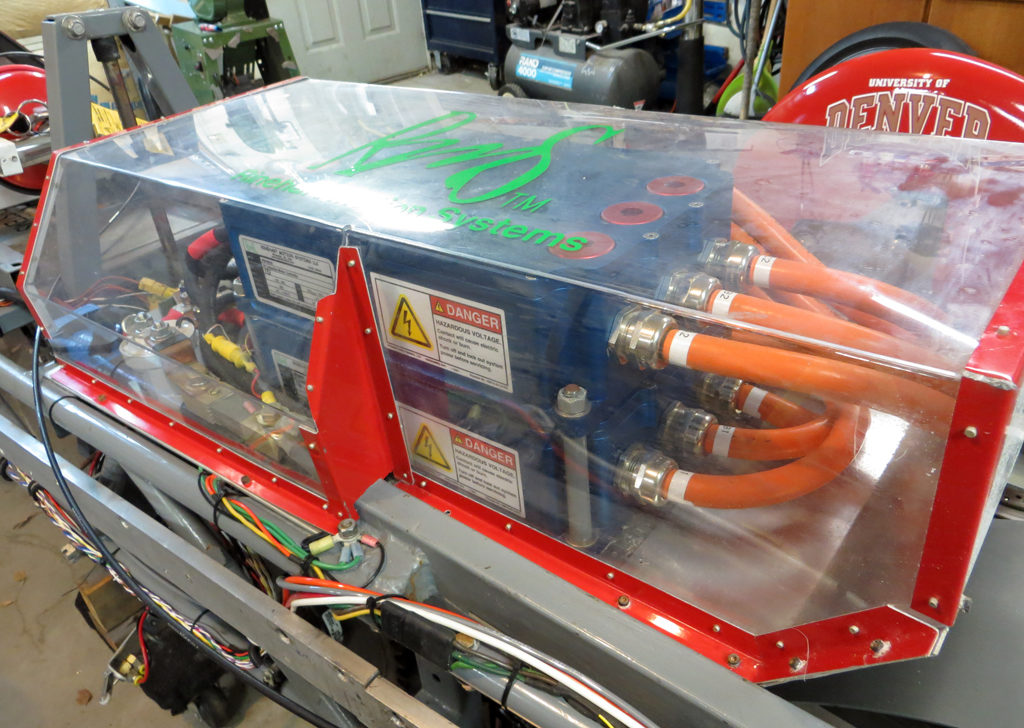 A salt-proof enclosure nicknamed “the aquarium” keeps salt (and fingers!) out of the high-voltage parts of the drivetrain. The two blue boxes are the Rinehart PM100 motor controllers.